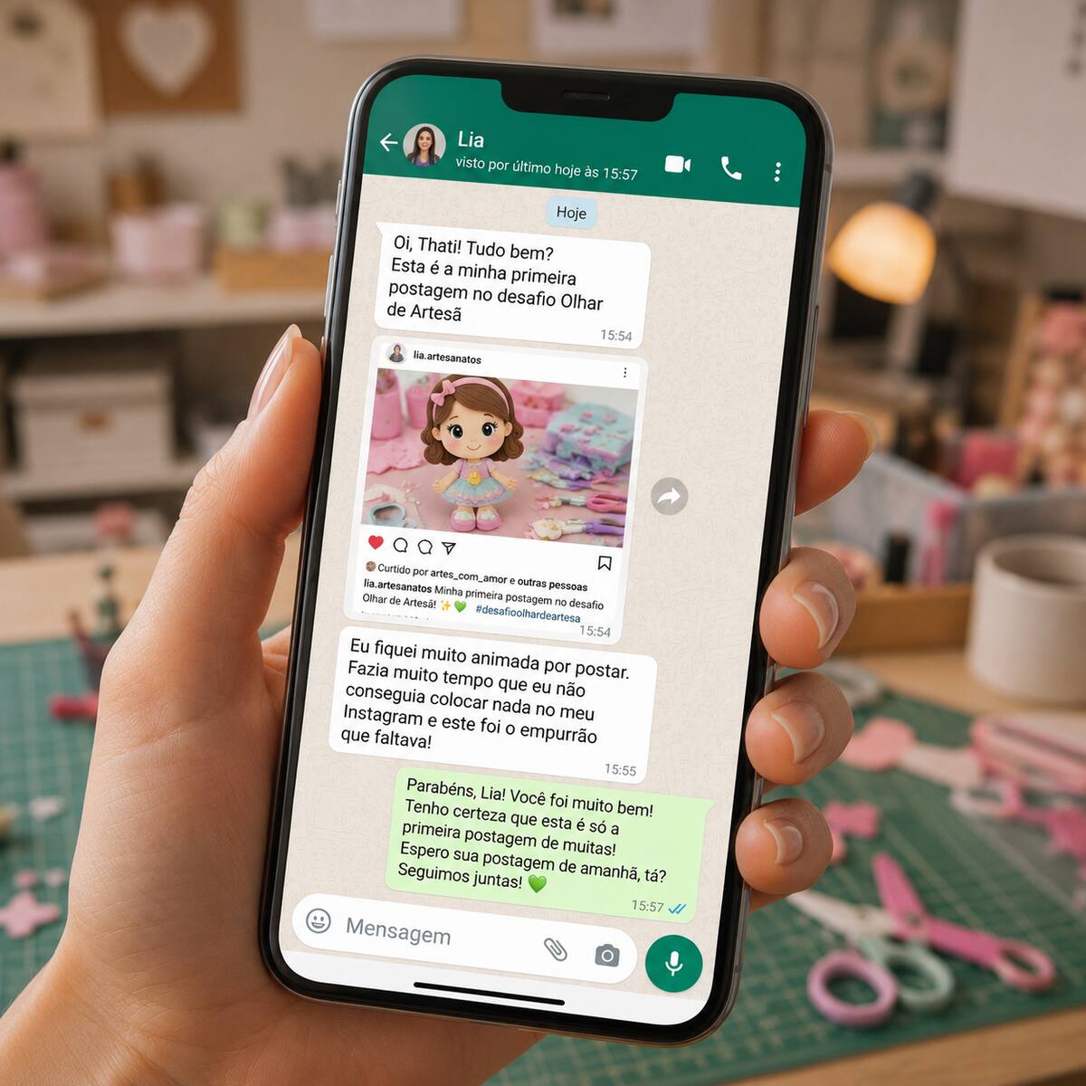 Mão segurando celular com conversa no WhatsApp em ateliê aconchegante